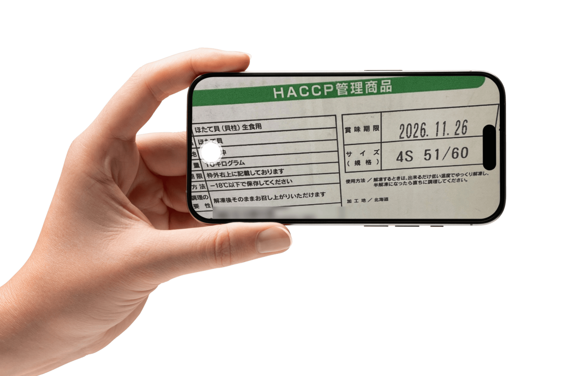 発泡スチロール箱に貼られた品質表示ラベルをスマートフォンで撮影している様子