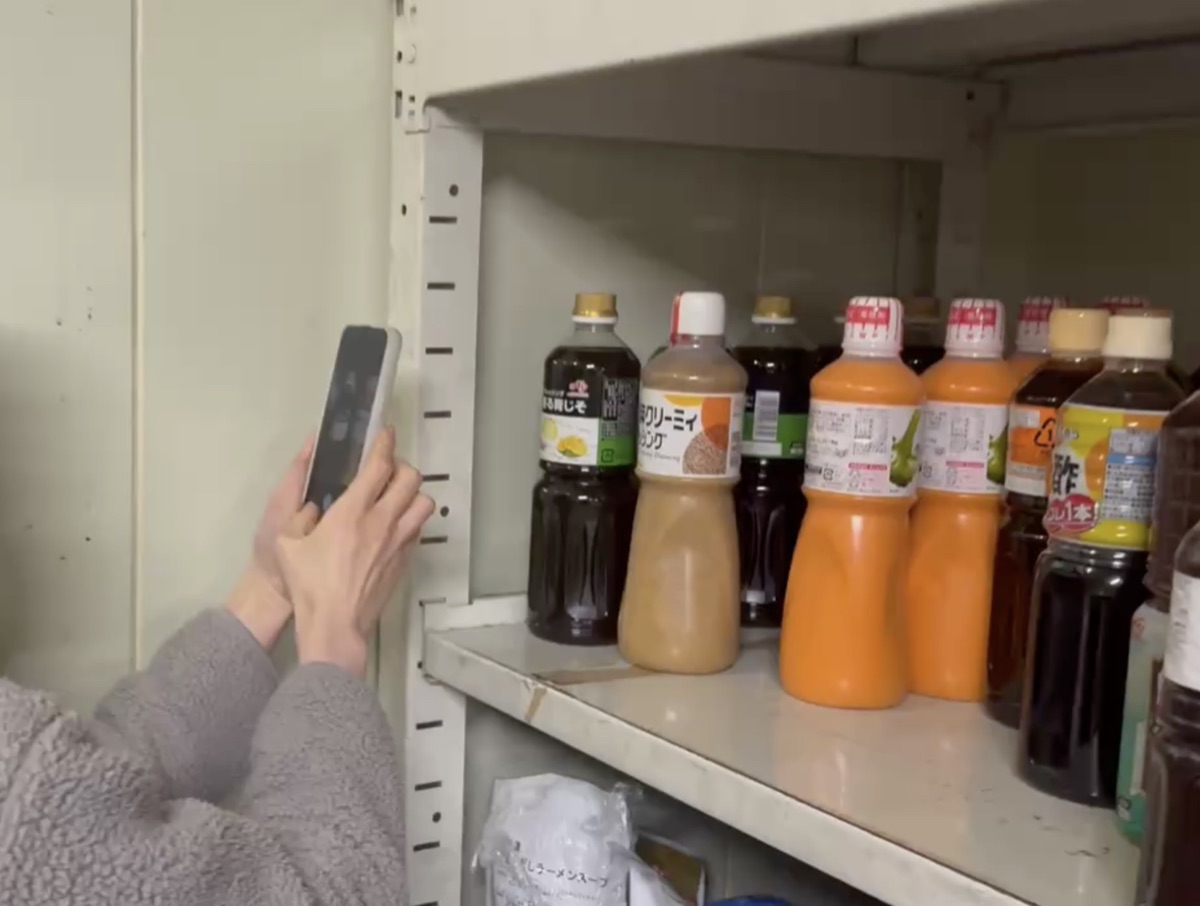 棚の商品をスマホで撮影して棚卸する様子